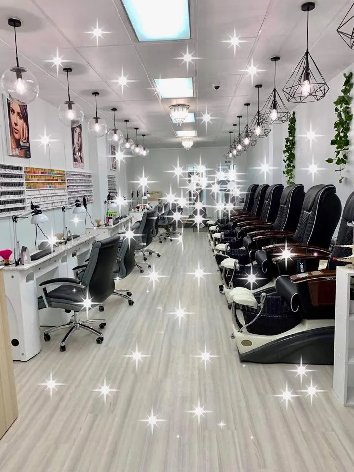 Inside the salon: white manicure stations on the left and dark pedicure chairs on the right